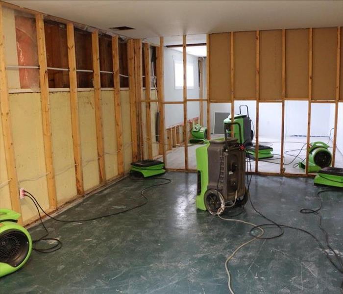 Air movers and dehumidifiers drying out a basement